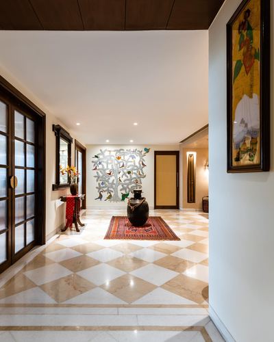 Marble-floored foyer with tree-of-life wall art, black urn, and framed painting on entry wall