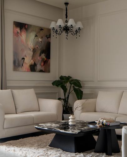 Beige living room with black chandelier, abstract art, and dark marble coffee tables