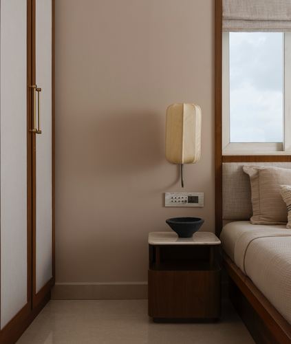 Bedroom corner with wooden nightstand, stone top, ceramic bowl, and fabric wall sconce beside window