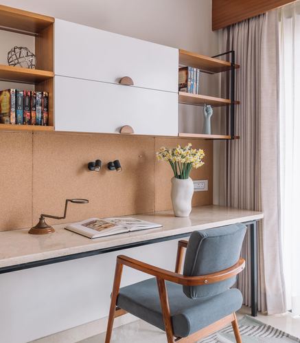 Wall-mounted study desk with cork backsplash, marble top, floating wood shelves and cane-armed chair