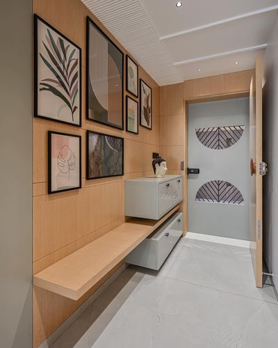 Entryway hallway with wood paneled wall, framed art gallery, floating console and patterned front door