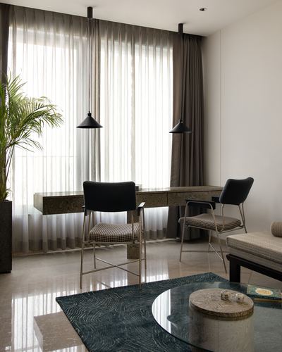 Study nook with sheer curtains, floating desk, two pendant lights and marble floor