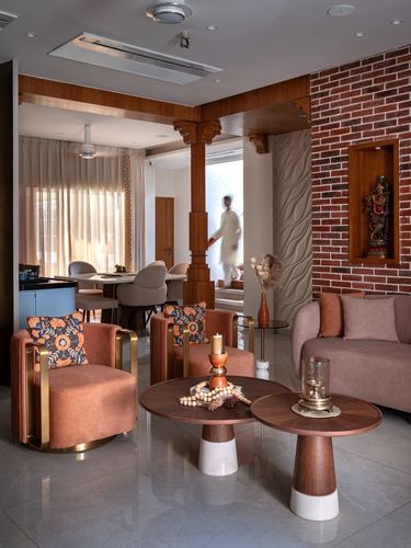 Living room with brick wall, carved wooden column, pink sofa, and pedestal coffee tables