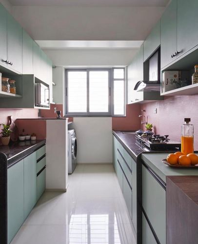 Mint green galley kitchen with pink textured backsplash and window at far end