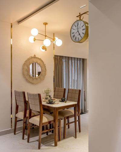 Dining nook with marble table, cane-back chairs, sputnik chandelier and macrame mirror on beige wall