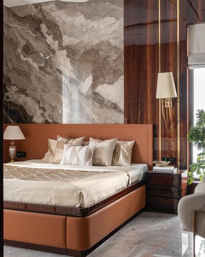 Luxury bedroom with rust leather bed, marble feature wall, and glossy wood paneling