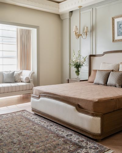 Elegant traditional bedroom with upholstered bed, nailhead trim, and patterned rug
