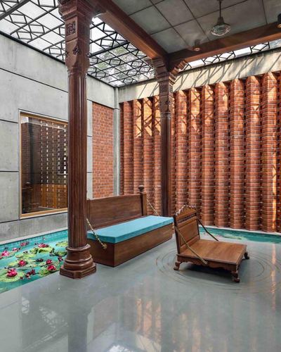Courtyard with carved wooden pillars, hanging wooden swings, lotus pond, and perforated brick wall