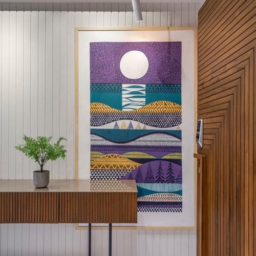 Foyer with ribbed wood door, wall panelling, console table and large colorful artwork