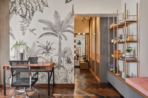 Home office with black and white tropical wallpaper opening to a hallway with an open brass shelving unit