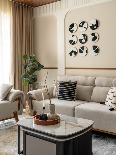 Beige living room with sectional sofa, arched niche, and black-and-white circular wall art