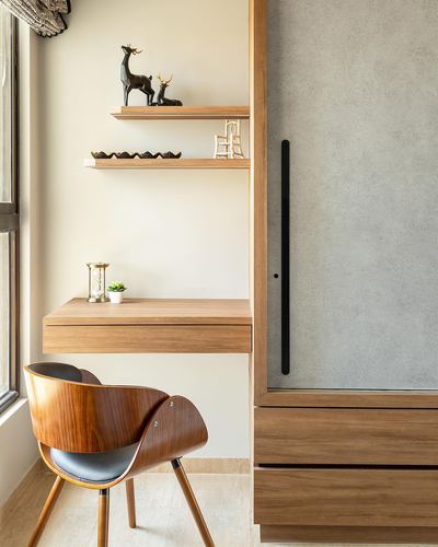 Wood floating desk and shelves beside a wardrobe with molded wooden chair