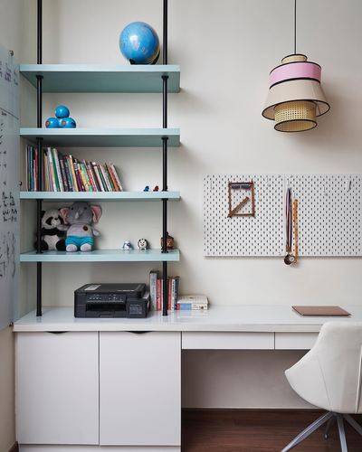 Kids study nook with mint shelving, pegboard wall, and tiered pendant light above white desk