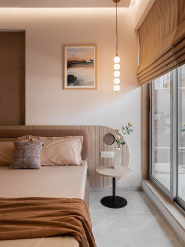 Bedroom with fluted wood headboard, round stone side table, and globe pendant light beside window