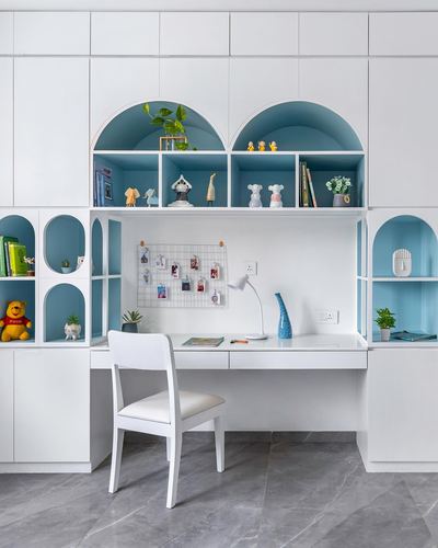 White built-in study unit with arched blue-backed niches, desk, chair and marble floor