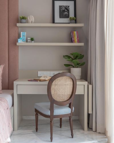 Study nook with cane-back chair, floating shelves, and marble-look floor in a neutral bedroom corner