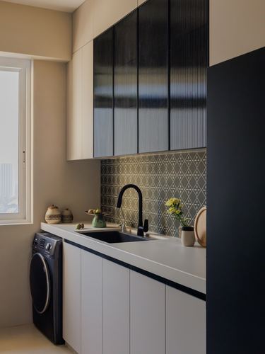 Small modern kitchen with black sink, patterned backsplash tile, and dark reeded upper cabinets.
