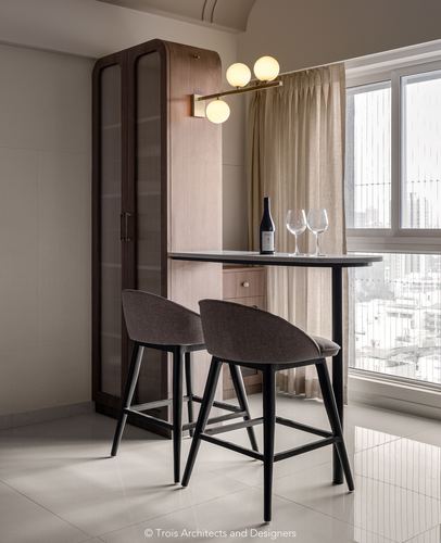Small bar table with two stools by a window, tall wood cabinet beside it