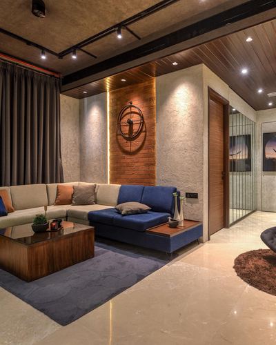 Industrial loft living room with navy and beige sectional, brick accent wall and wood ceiling