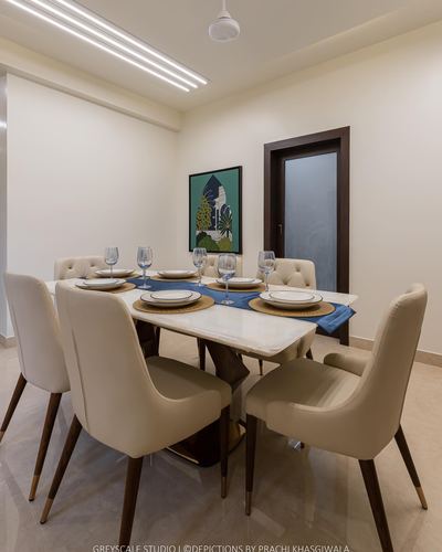 Dining room with marble table, cream chairs, blue runners, and green botanical artwork on wall