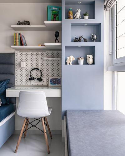 Child's study nook with pegboard desk and blue wall niches holding toys