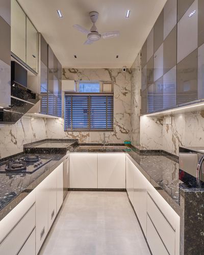 U-shaped modern kitchen with marble backsplash, dark stone counters, and glossy white cabinetry