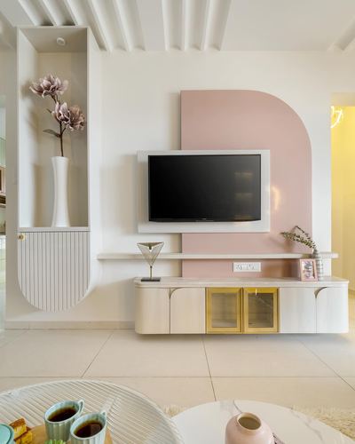 Pastel living room with floating stone TV console, arched pink wall panel, and fluted niche with vase