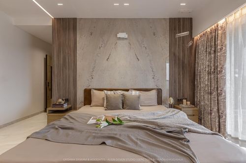 Neutral toned bedroom with fluted wood panels, veined stone feature wall, and upholstered bed