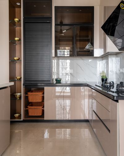 U-shaped kitchen with glossy beige cabinets, black countertop, marble-look backsplash and open brass display shelves
