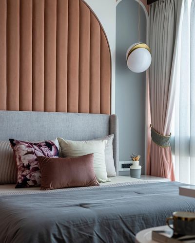 Bed with grey upholstered headboard against terracotta arched fluted panel and pink curtains
