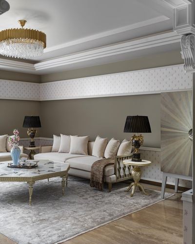 Formal living room with cream sofa, brass lamps, crystal chandelier and marble coffee table