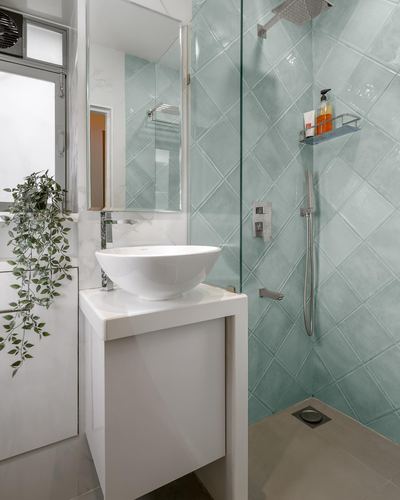 Small bathroom with white vessel sink and mint diamond-tiled glass shower enclosure