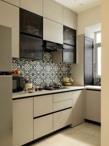 L-shaped kitchen with beige cabinetry, black fluted glass uppers, and patterned tile backsplash