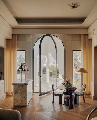 Dining area with arched glass door, marble bar, herringbone floor and patterned chairs, Amman