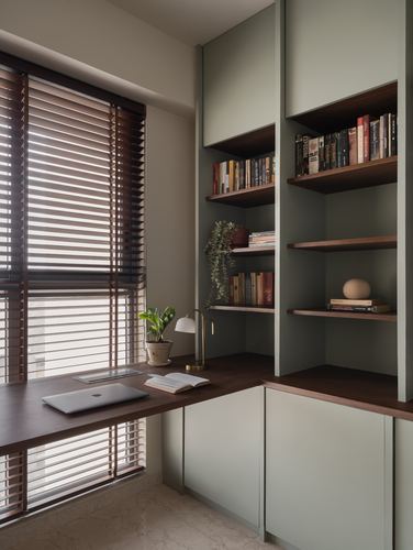 Corner study with walnut desk, sage cabinetry, open bookshelves and wooden blinds filtering daylight