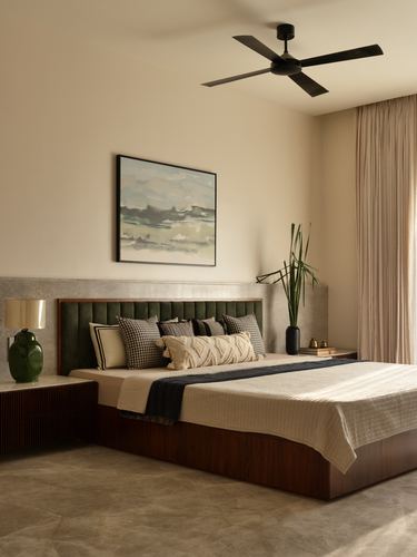 Bedroom with green velvet headboard, wooden bed base, stone accent wall and abstract painting