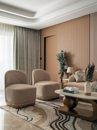 Living room with fluted wood wall, two beige swivel chairs and marble coffee table on patterned rug