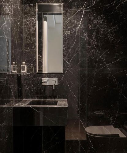 Dark veined marble bathroom with rectangular mirror, marble vanity and matching toilet surround