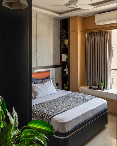 Bedroom with black-framed bed, terrazzo wall, wooden shelving alcove and window seat