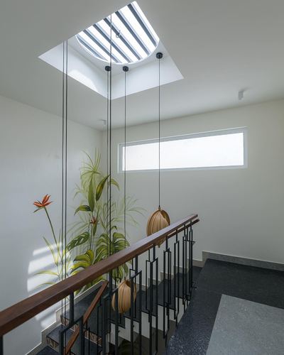 Stairwell landing with skylight, mural wall, wooden pendant lights and dark terrazzo floor