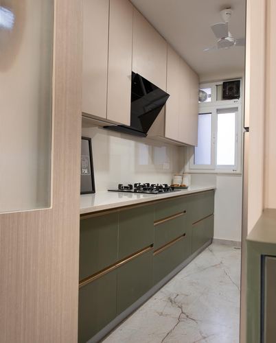 Galley kitchen with olive-green base cabinets, beige upper cabinets, black chimney hood, and marble-look flooring