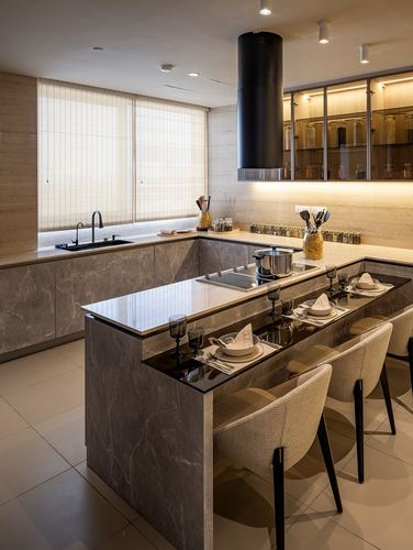 Modern kitchen with marble-look island, black cylindrical hood, and dining seating along the counter