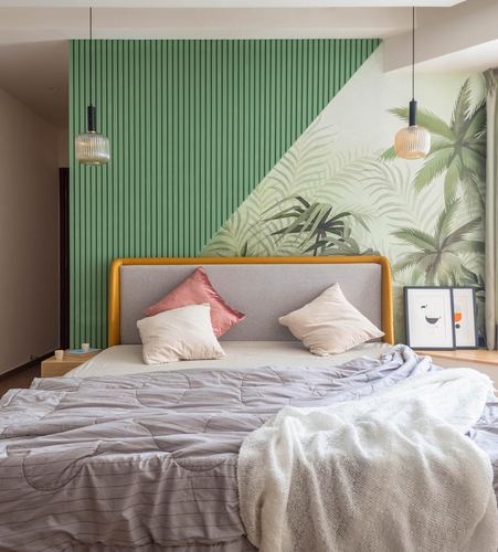Bedroom with green fluted wall, palm mural, mustard-trimmed grey headboard and two pendant lights