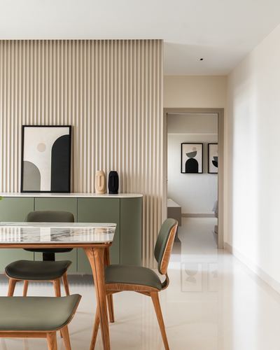 Minimalist dining area with fluted wood wall, sage green sideboard, and marble-top table