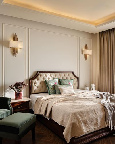 Classic bedroom with tufted leather headboard, wood furniture, and cove-lit ceiling in warm tones