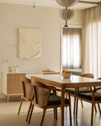 Warm-toned dining room with cane-back wooden chairs and a stone-top table
