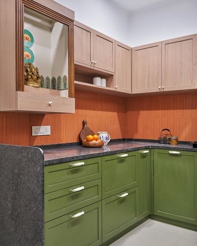 L-shaped kitchen with olive green cabinets, wood-toned uppers, terracotta backsplash and a pooja niche