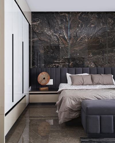 Bedroom with dark bookmatched stone feature wall, charcoal tufted headboard and glossy white wardrobe