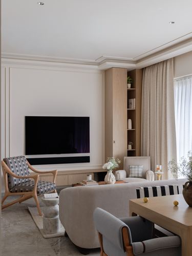 Beige living room with wall-mounted tv, wood shelving niche, and layered neutral seating