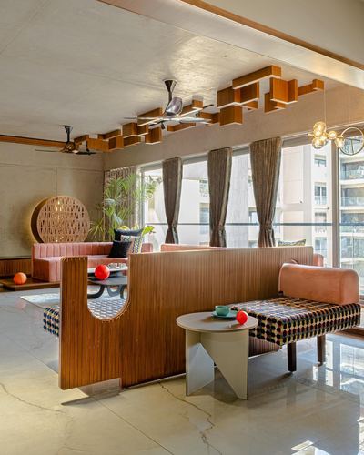 Living room with ribbed wood partition, sculptural ceiling shelving, terracotta sofa and marble flooring